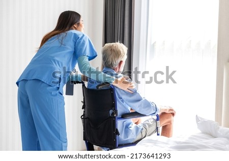 Caregiver nurse take care a Senior patient sit on wheelchair. Nurse helping senior Man Royalty-Free Stock Photo #2173641293