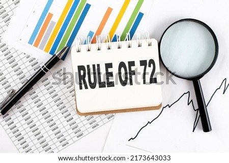 RULE OF 72 text on a notebook on the graph background with pen and magnifier Royalty-Free Stock Photo #2173643033