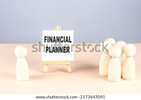 FINANCIAL PLANNER text on easel with wooden figure, meeting concept