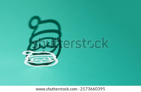 Silhouette of Santa Claus with a shadow on a blue background. New Year and Christmas background. Copy space.