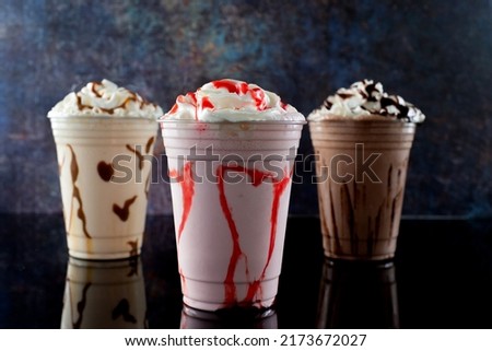 Milkshakes of different flavors on a dark background.
