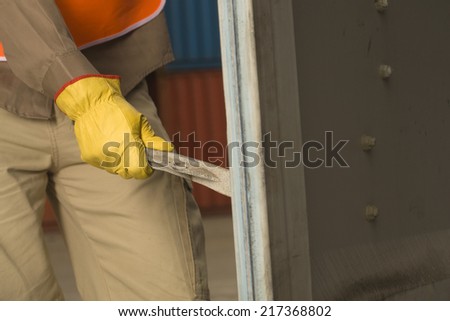 Mid section view of a dock worker opening a cargo container