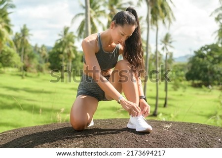 A Beautiful fit woman in sportswear tying shoe laces get ready for exercising, Health and sport concept. Royalty-Free Stock Photo #2173694217