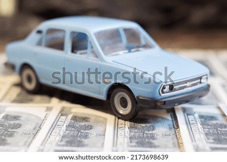 Toy car on banknotes. Rise in the cost of fuel due to the war in Ukraine