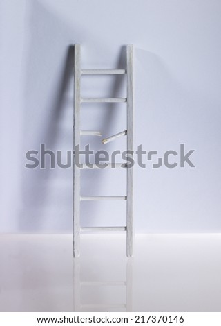 Broken ladder leaning on wall Royalty-Free Stock Photo #217370146
