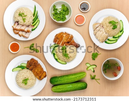 Chicken Cutlet and Roast Pork Rice, Roast Pork, Roasted Chicken, Roast Pork, Steamed Chicken with raw cucumber, Coriander, salad, sauce and soup served in a dish isolated on wooden background top view Royalty-Free Stock Photo #2173712311