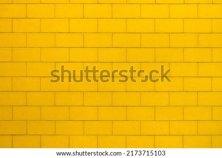 Background with the texture of a brick wall painted in yellow color Royalty-Free Stock Photo #2173715103