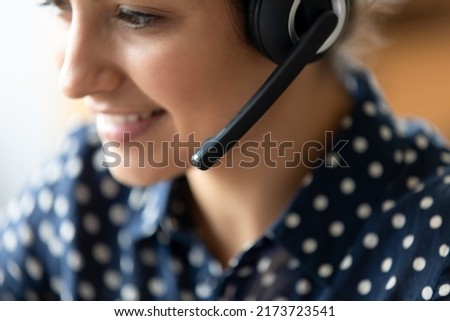 Close up indian ethnicity woman helpline operator employee company representative wear wireless headset talk to client provide support remotely. Distance webinar, online professional tutoring concept Royalty-Free Stock Photo #2173723541