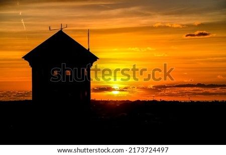 Silhouette of a lonely house against the sunset. Lonely house at sunset. Sunset house view. House at sunset Royalty-Free Stock Photo #2173724497
