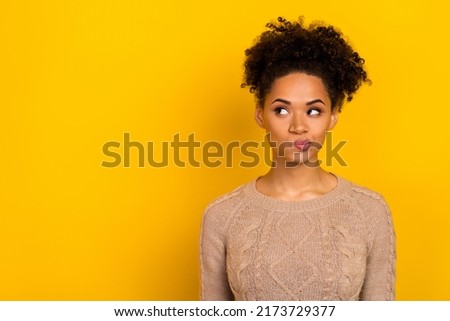 Photo of doubtful unsure lady dressed beige pullover looking empty space isolated yellow color background Royalty-Free Stock Photo #2173729377