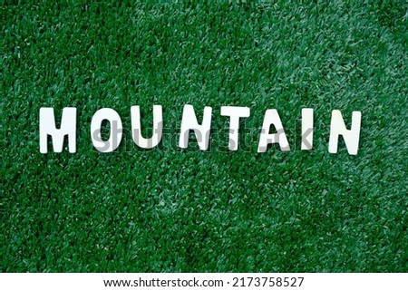 Word Mountain on green background. Mountain means a large natural elevation of the earth's surface rising abruptly from the surrounding level; a large steep hill.; word related to nature. Royalty-Free Stock Photo #2173758527