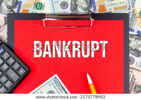 BANKRUPT - word on the background of money (dollars), a notepad and a pen with a calculator. Business concept (copy space). Royalty-Free Stock Photo #2173778903