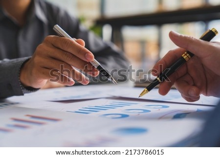 Bookkeeper accountant or financial expert, male economist accounting money with statistics graphs pointing on the accounts for investment results and income Company expenditure  Royalty-Free Stock Photo #2173786015