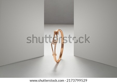 Golden bracelet on white dramatic background with copy space Royalty-Free Stock Photo #2173799529