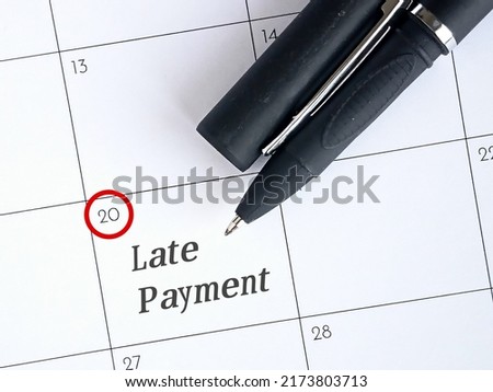 Late payment text reminder with pen on calendar. Photo concept.  Royalty-Free Stock Photo #2173803713