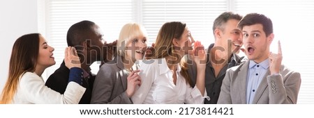 Business Colleague Whispering Secret Gossip To An Amazed Shocked Man With Wide Open Mouth Royalty-Free Stock Photo #2173814421