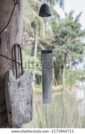 Japanese wind chime hanging in the wooden house. Translation on the wood "peace". "toughness is determined by at least 3 things, namely: the style of the blade shape, materials and forging techniques"