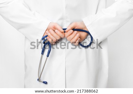 Doctor holding stethoscope behind his back