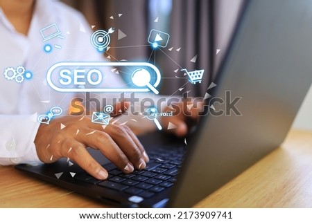 A man in a white shirt is using a laptop to search the internet and is using SEO or search engine optimization as a search engine to get better results and more efficiency. Marketing and technology.