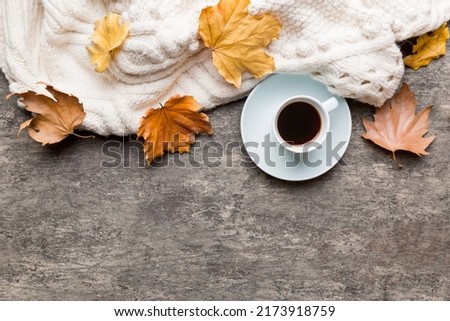 Flat lay composition with colorful Autumn cup of coffee and leaves on a color background. top view.