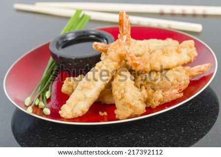 Ebi Tempura - Prawn tempura served with soy sauce on a granite background.