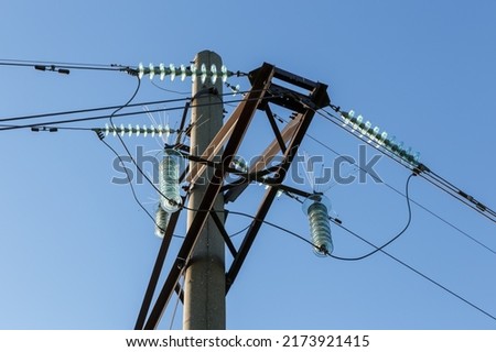 Concrete electricity pylon with glass insulators and bird spikes. Electric power concept. Bird protection for power lines.