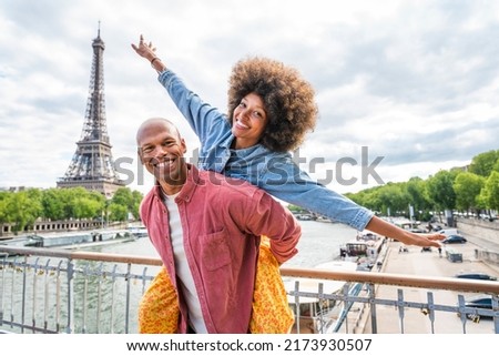 Black cheerful happy couple in love visiting Paris city centre and Eiffel Tower - African american tourists travelling in Europe and dating outdoors Royalty-Free Stock Photo #2173930507