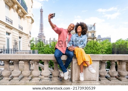 Black cheerful happy couple in love visiting Paris city centre and Eiffel Tower - African american tourists travelling in Europe and dating outdoors Royalty-Free Stock Photo #2173930539