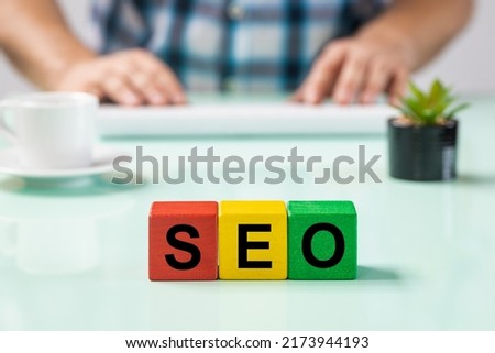 Office worker at the computer, wooden blocks, SEO, Search Engine Optimization, the process of improving the amount of traffic in relation to the positioning of the page from the search results