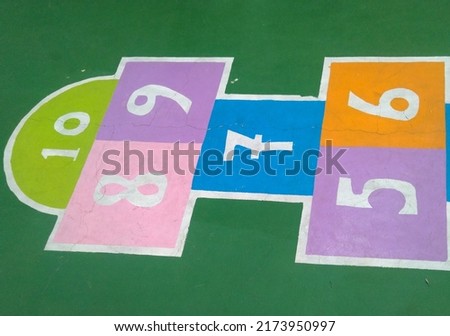 Hopscotch playing area at park. Isolated colorful hopscotch line with number painted on park ground. Hopscotch playing area at a playground. 5-10 hopscotch number. One foot jumping game for children