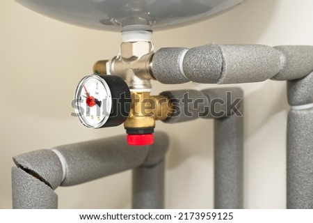Pressure gauge on domestic boiler expansion vessel inside house Royalty-Free Stock Photo #2173959125