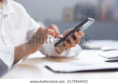 Close-up photo of female hands using the phone, business woman at work.