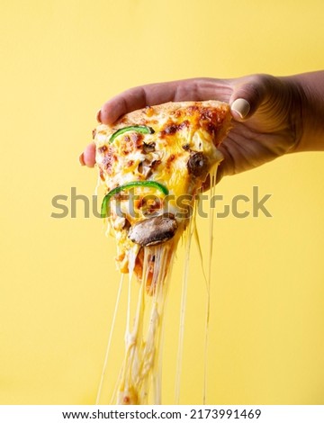 Taking pizza slice up with cheese Stretching    Royalty-Free Stock Photo #2173991469