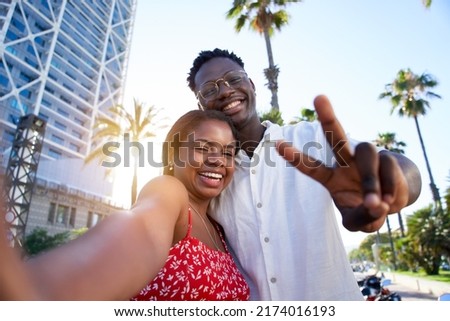 Selfie of a young black couple looking at camera smiling. Concept of vacation and relationship. African American couple having fun enjoying holidays Royalty-Free Stock Photo #2174016193