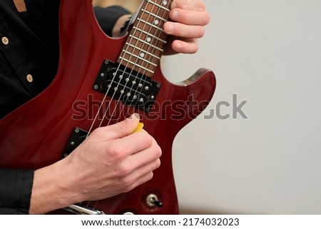 man playing electric guitar with pick on white background stock photo
