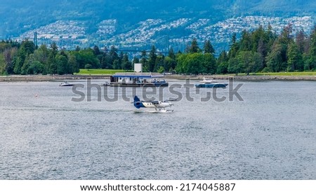 A view towards Stanley Park of a floatplane taking off in Vancouver, Canada in summertime