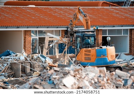Demolition of building. Excavator breaks old house. Making space for the construction of a new houses Royalty-Free Stock Photo #2174058751