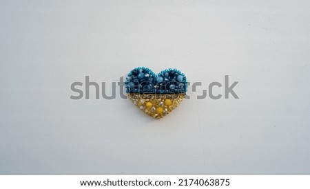 Brooch in the shape of a heart in the colors of the Ukrainian flag