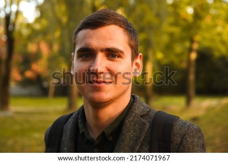 Defocus portrait young man on nature autumn background. Smiling young man. 20s years. Handsome man outdoors portrait. Walking in park. Lifestyle. Student. Out of focus.  Royalty-Free Stock Photo #2174071967