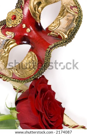 An ornate venetian mask with a single red rose