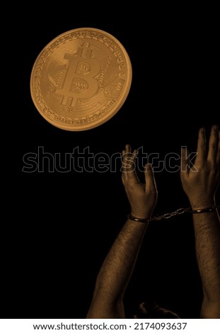 Hands in handcuffs and bitcoin over dark background. Crypto crime concept. 