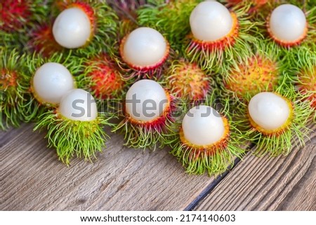 Fresh and ripe rambutan sweet tropical fruit peeled rambutan, Rambutan fruit on wooden background harvest from rambutan tree in the garden 