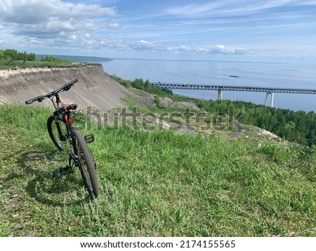 bicycle standing on the slope of the river against the background of the bridge