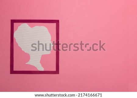 pink frame with paper woman silhouette with lines on the left side of the background, right part copy space, creative modern design, woman on the pink background