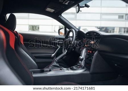 Modern supercar interior with the leather panel, sports seats, multimedia, and digital dashboard.  Royalty-Free Stock Photo #2174171681