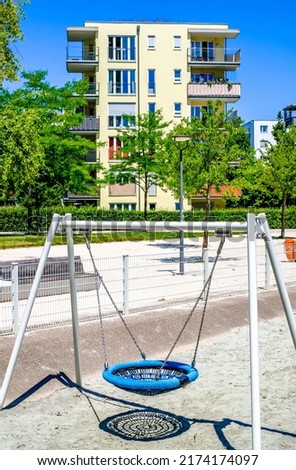 playground in front of a modern concrete plattenbau facade - photo