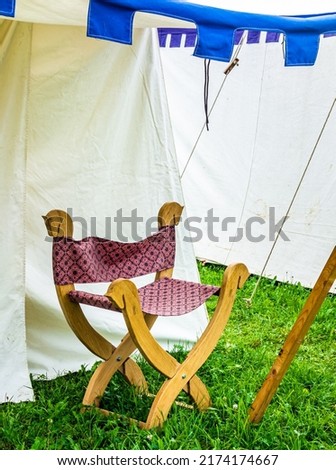 old fashioned chair in front of tent - photo