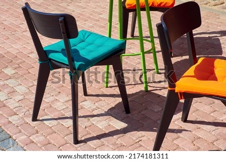 Street cafe chairs with bright colored cushions.