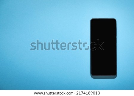 Black smartphone on the blue background.