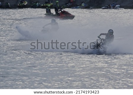 Athletes ride jet skis and spray water in water sports racing.Jet ski racing competition and water splash.Extreme outdoor water sport concept.